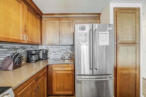 The fully equipped kitchen features quartz countertops, stainless-steel appliances, and has everything you need to prepare meals for family & friends.