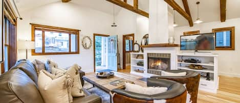 Vaulted ceilings, Wood-burning fireplace, flatscreen TV, and Sonos stereo system