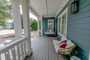 Large wrap around porch to sit and relax after a long day at the beach