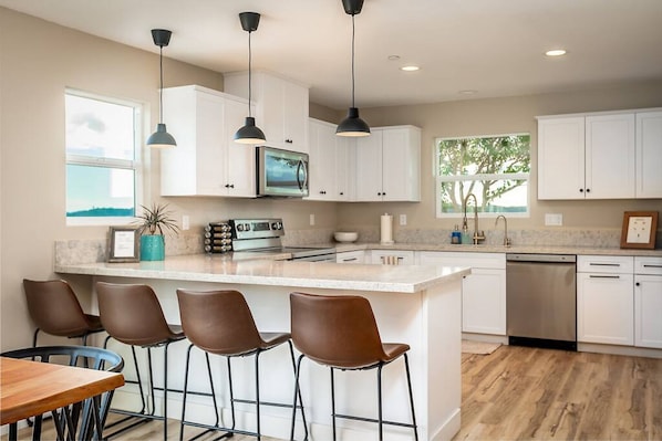 Indulge in culinary delights with a kitchen built to impress - stainless steel appliances, spacious island, and plenty of room for four to dine in style at our stunning vacation rental.