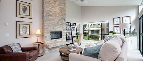 Living room with gas fireplace and ample light.