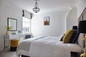 this generous ensuite bedroom has feather pillows & a medium kingsize mattress