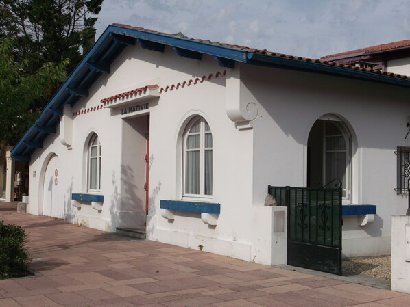 Maison vue de la place avec le garage à gauche