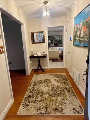 Foyer with guest table, living room straight ahead and game room to left