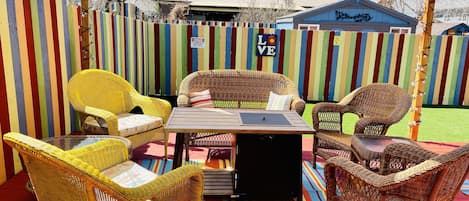 Cozy colorful outdoor patio seating with gas fire pit table.