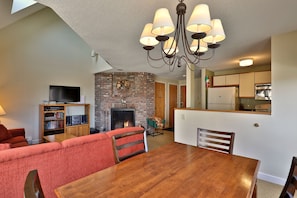 View from the dining area into the living room with wood burning fire place