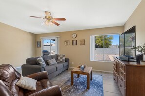 A view from the front door shows the living area and TV with Roku Streaming