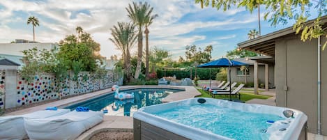Backyard Oasis featuring a heated pool, hot tub and more!