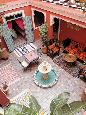 Le patio arboré avec sa fontaine centrale