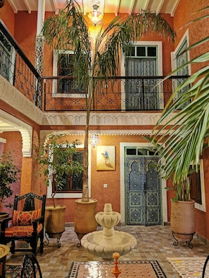 Le patio arboré avec sa fontaine centrale