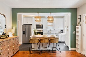 Fully stocked chef's kitchen opens to living room and balcony