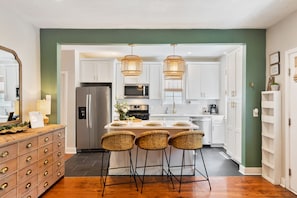 Fully stocked chef's kitchen opens to living room and balcony