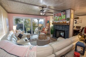 Living Room with HD Smart TV, Fireplace, and Glass Doors which lead out onto Covered Porch with Mountain Views