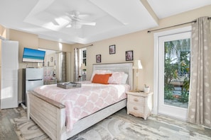 Master bedroom with queen-sized bed, mini-refrigerator, TV.