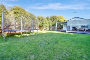 Rear yard with large trampoline. All fenced off.