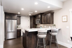 Modern gourmet kitchen features stainless steel appliances & counter top dining.