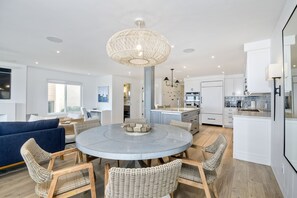 Round dining room table with seating for six and an ocean view