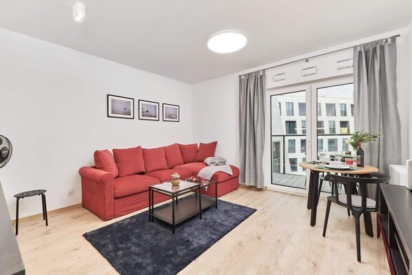 The living area features a sleek coffee table and a flat-screen television.