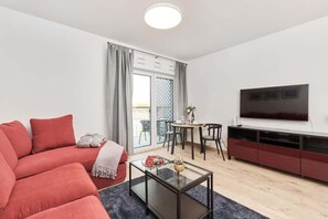 The elegant living area featuring a double sofa bed and television.