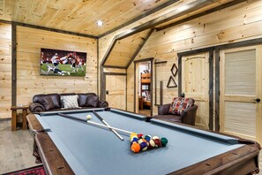 Game room with 65" TV, regulation pool table, and seating to enjoy