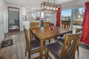 Cozy and inviting dining area with warm wooden furniture, modern lighting, and a bright view of the backyard—perfect for family meals and gatherings!