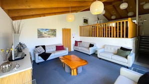 Lounge room looking towards the mezzanine level of the kitchen and dining area