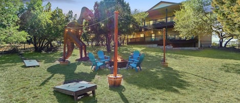 Upper and lower decks of the home look out over the fire pit and T-Rex statue.