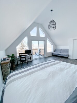 Spacious primary bedroom with beautiful windows looking out on the lake.