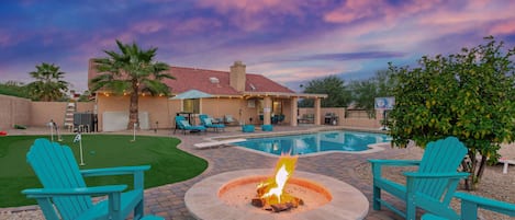 amazing backyard, complete with heated pool, hot tub, patio lounge and dining table, fire pit and even a putting green to practice your skills.