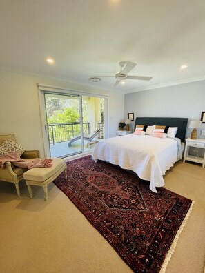 Master bedroom upstairs with doors onto balcony overlooking ocean.