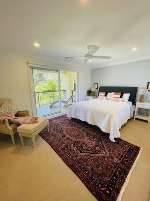 Master bedroom upstairs with doors onto balcony overlooking ocean.