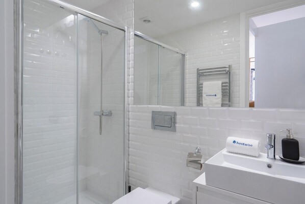 The bathroom is equipped with towels, hair dryer and shampoo.