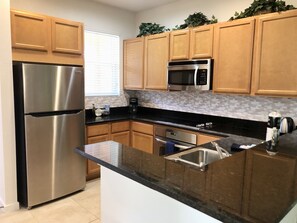 Spacious kitchen with stainless appliances and solid surface countertops