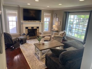 Main floor living room with electric fireplace and 65" smart TV