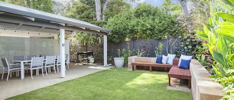 Unwind in the beautifully landscaped backyard, where vibrant greenery, built-in seating, and a peaceful atmosphere make it the perfect spot to relax.