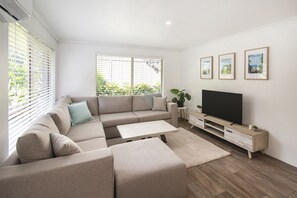 Sink into the plush L-shaped sofa and enjoy your favourite shows on the smart TV, or simply bask in the natural light streaming through large windows.