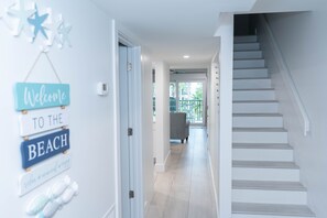 Open spacious entrance - modern beachy decor with porcelain wood plank floors