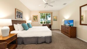 Primary bedroom with a king size bed, TV and ceiling fan