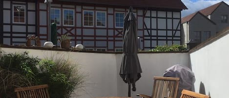 Patio mit Esstisch, Stühlen, zwei Liegen und Grill