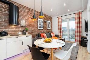 Living room with double sofa bed, TV, access to the balcony and dining area.