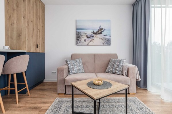 A cozy living room with a wooden coffee table, stylish chairs, and modern artwork on the wall.
