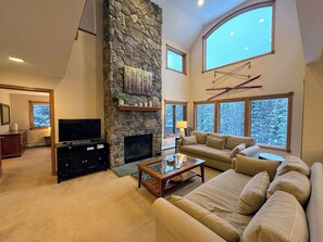 Spacious Living Areas: Enjoy the warmth of the stone fireplace in the main living room, or step onto the outdoor deck to soak in breathtaking mountain views.
