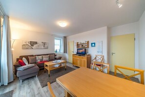 Wohnbereich mit Sofa, Couchtisch und Esstisch