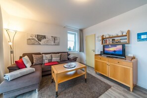 Wohnbereich mit Sofa, Couchtisch und TV