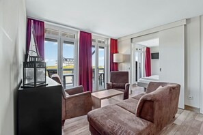 Wohnbereich mit Sofa, Sessel, Couchtisch mit Zugang zum Balkon