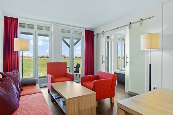 Wohnzimmer mit Couch, Couchtisch und Sessel