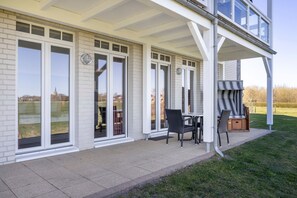 Überdachte Terrasse mit Sitzgelegenheit und Strandkorb