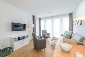 Wohn/Essbereich mit Sesseln, Couch, Esstisch und TV