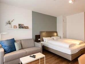 Wohn/Essbereich mit Doppelbett, Couch und Kleiderschrank