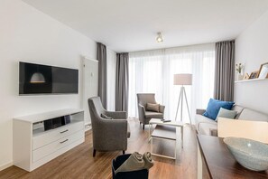 Wohn/Essbereich mit Esstisch, Couch, Sesseln und TV